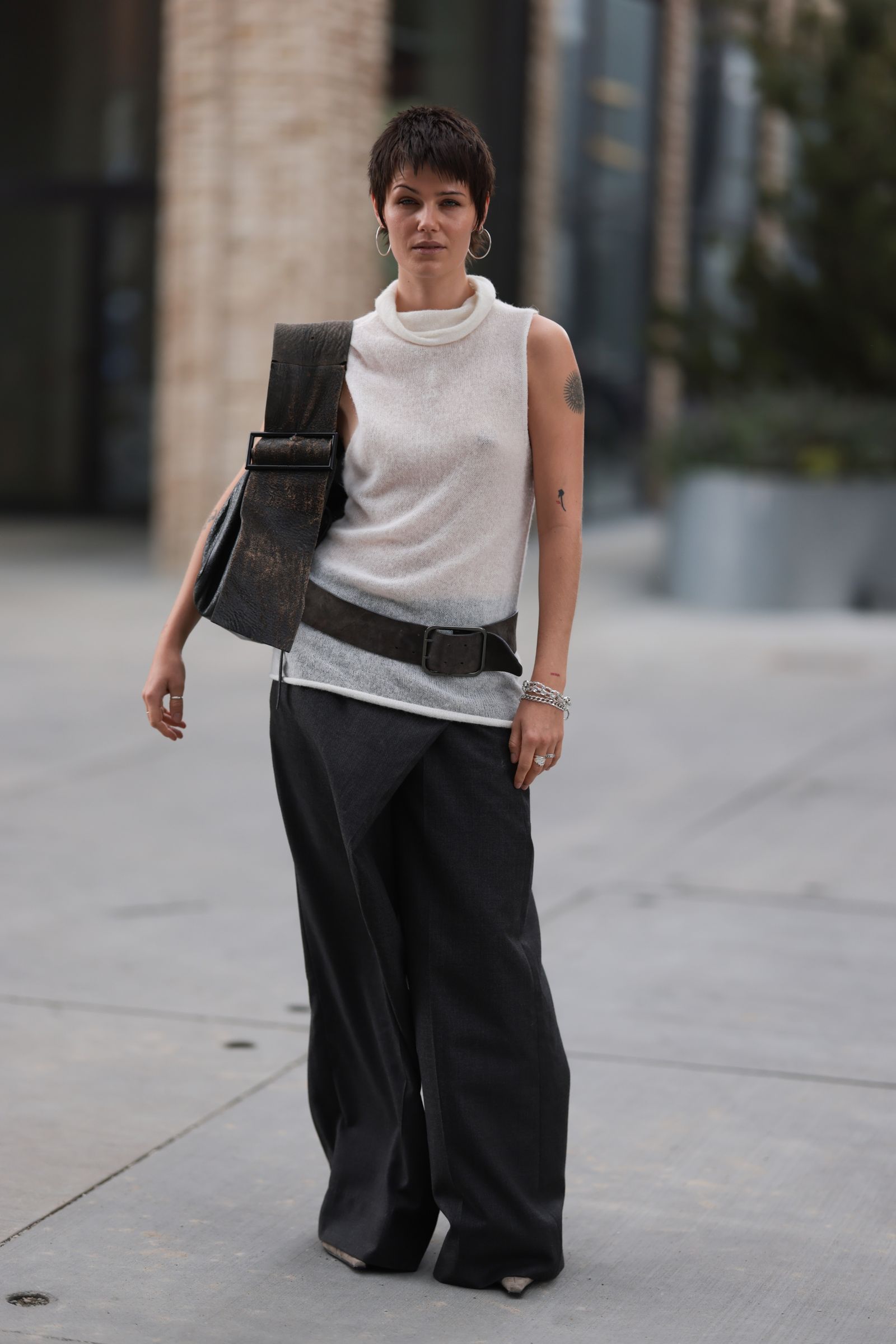 Mujer luce en el street style una blusa tejida con jeans acampanados con pareo