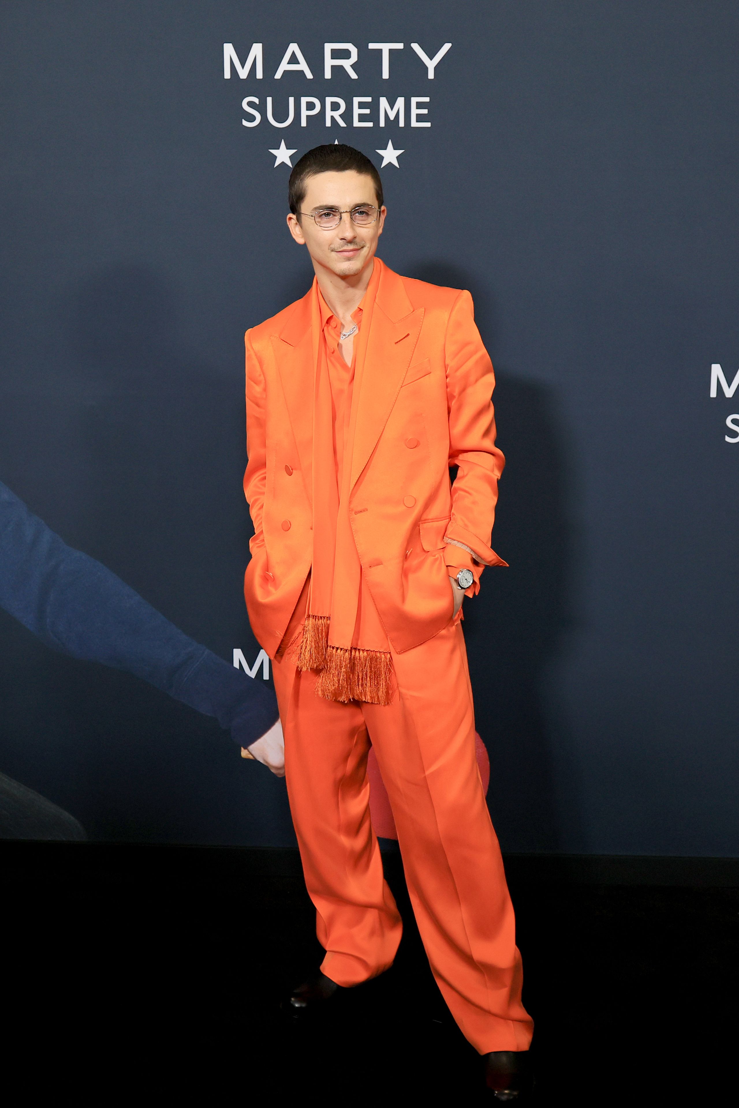 Image may contain Timothe Chalamet Clothing Formal Wear Suit Coat Adult Person Standing Fashion Face and Head