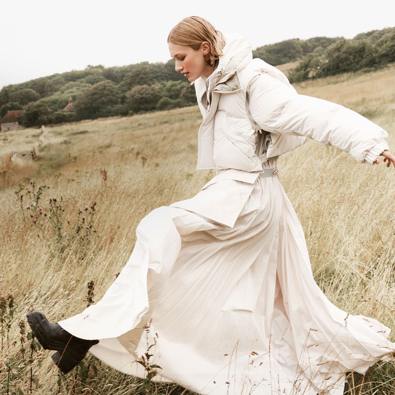 Image may contain: Yumi Lambert, Clothing, Coat, Dress, Grass, Plant, Adult, Person, Wedding, Fashion, Formal Wear, and Gown